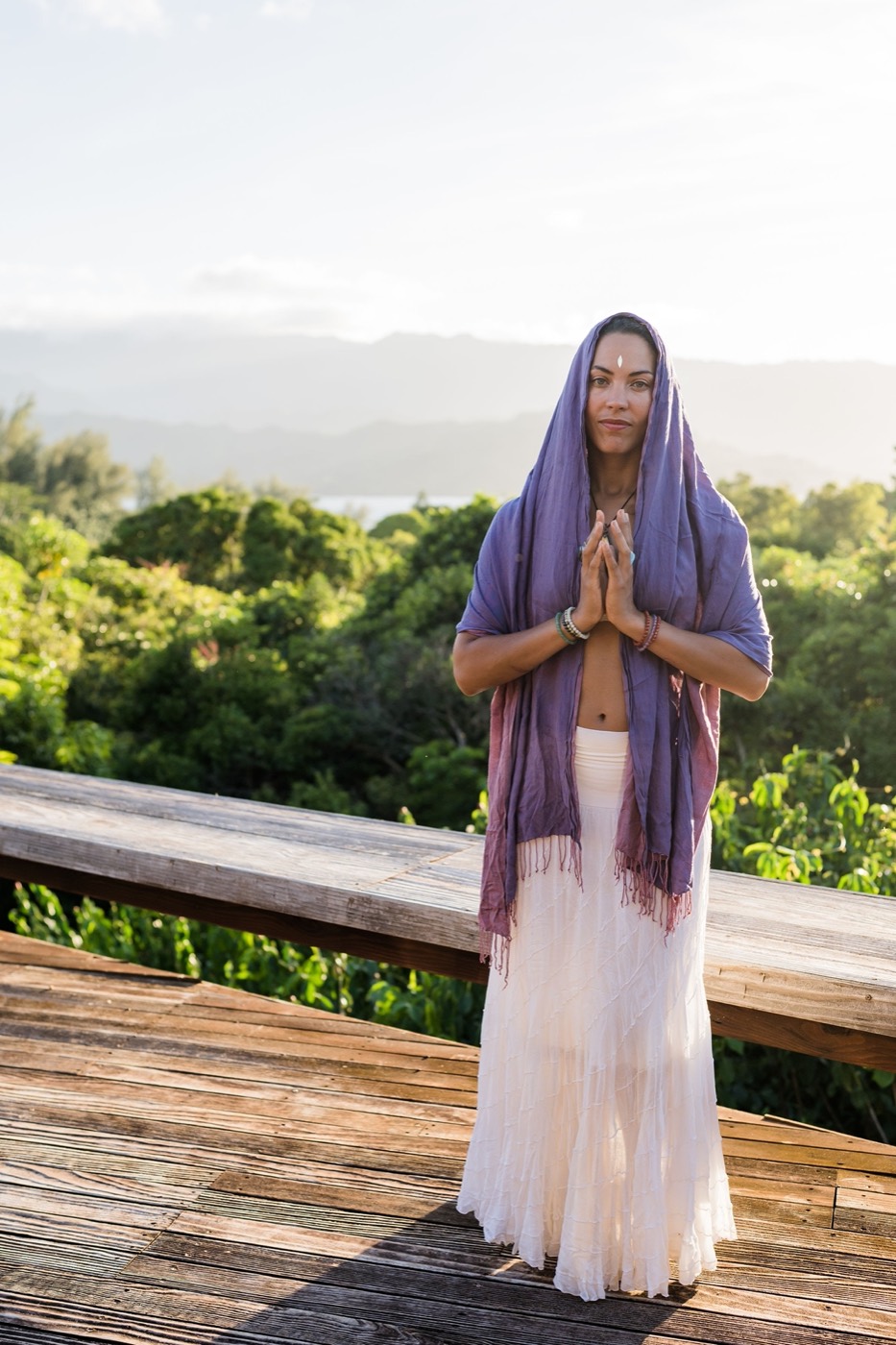 Donica standing in a meditative prayer pose at golden hour